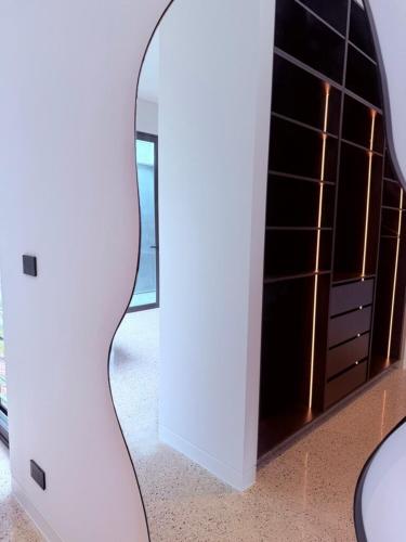 a mirror on a wall next to a cabinet at Huzzah! in Theresa Park