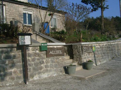 a brick wall with a sign for a garden at Chez Louis chambres d'hôtes à la ferme in La Canourgue