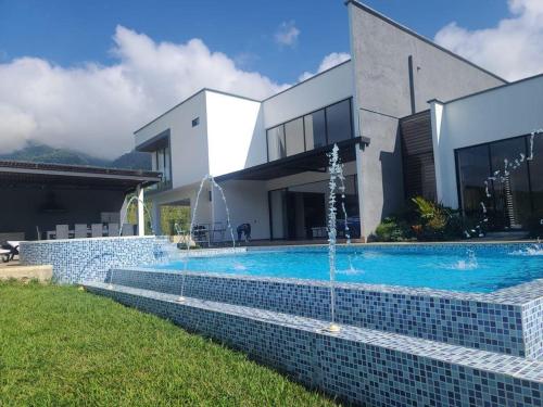 a swimming pool in front of a house at Hermosa Casa de Lujo en LAGO CALIMA in Darién