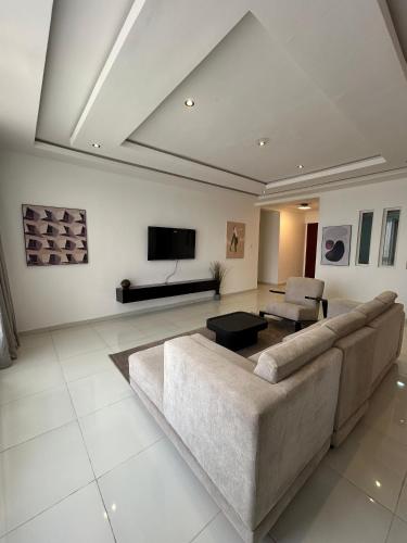 a living room with a couch and a tv at Haven apartment Ikoyi in Obalende
