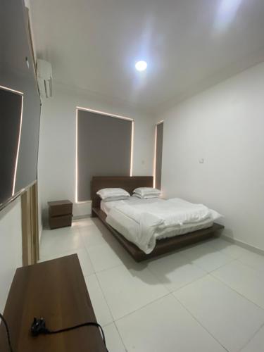 a bedroom with a bed and a table in it at Haven apartment Ikoyi in Obalende