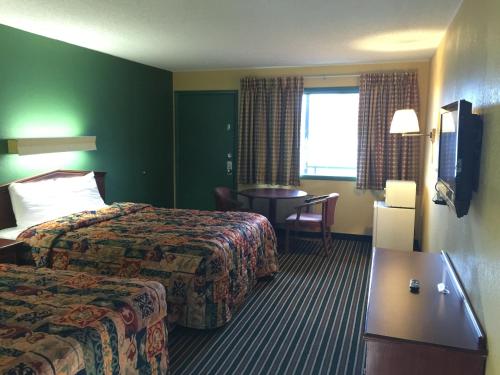 a hotel room with two beds and a table at Family Budget Inn Harrison in Harrison