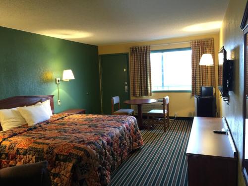 a hotel room with a bed and a table at Family Budget Inn Harrison in Harrison