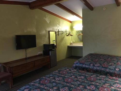 a hotel room with a bed and a flat screen tv at Family Budget Inn Harrison in Harrison