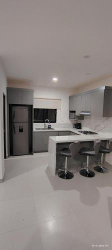 a large white kitchen with a large marble counter top at Condo located 8 min from DT & 15 min from Airport in San José del Cabo
