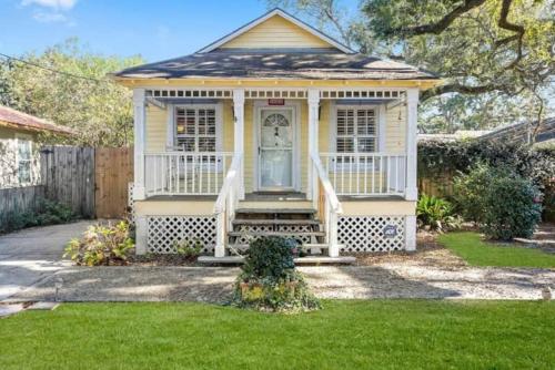 a small yellow house with a porch and a door at Walk to the Beach! in Gulfport