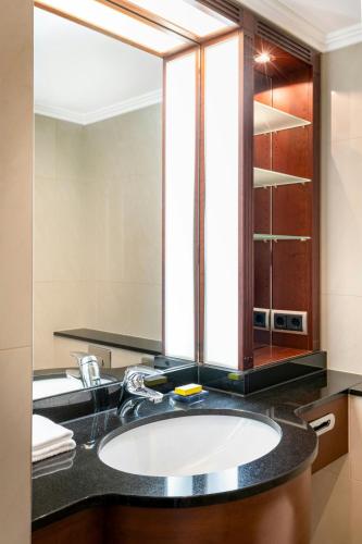 a bathroom with a sink and a mirror at Munich Marriott Hotel in Munich