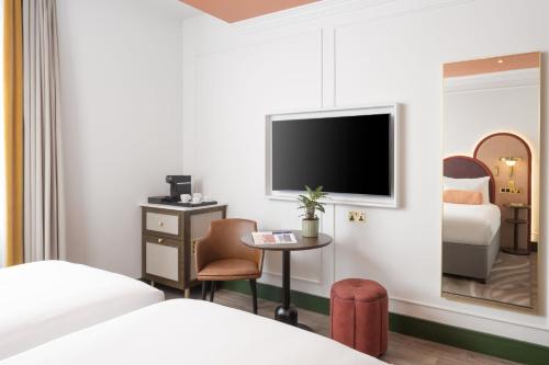 a hotel room with a bed and a television at The Welbeck Hotel by IHG in London