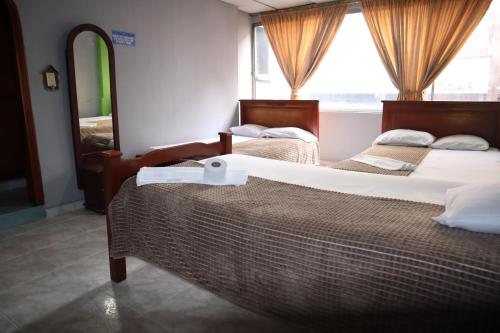 アルメニアにあるHotel casa realのベッドルーム1室(ベッド2台、鏡、窓付)