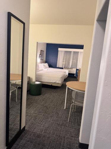 a mirror in a room with a bed and a table at Spark By Hilton Tucson Airport in Tucson