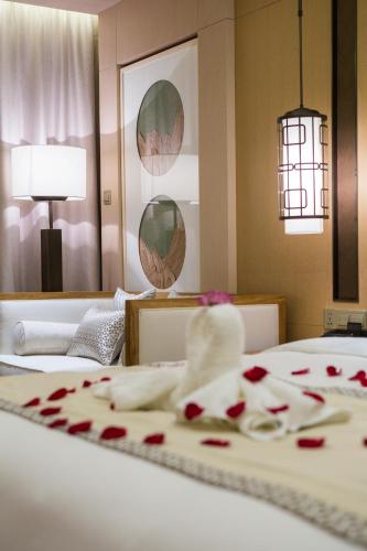 a room with a bed with red roses on it at Wyndham Grand Plaza Royale Wenchang in Wenchang