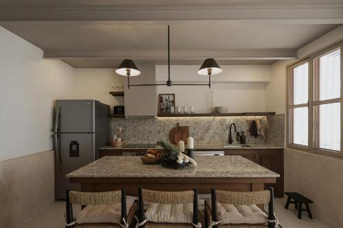 a kitchen with a table with chairs and a refrigerator at Casa Meraki Mérida - Paseo de Montejo in Mérida