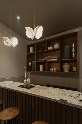 a kitchen with a counter with chairs and lights at Casa Meraki Mérida - Paseo de Montejo in Mérida
