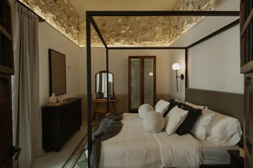 a bedroom with a large white bed in a room at Casa Meraki Mérida - Paseo de Montejo in Mérida