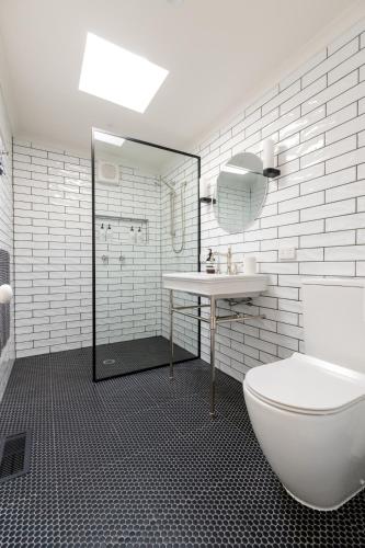 a white bathroom with a sink and a toilet at Waterside Cottage in Daylesford