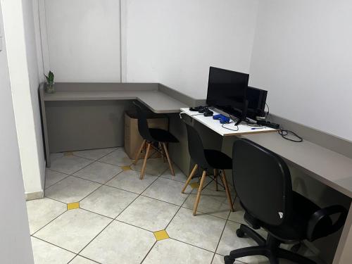 an office with two desks with a computer and two chairs at Terraza hostel in Itajaí