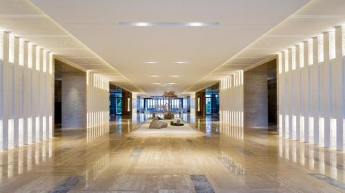 a hallway of a building with white walls and wooden floors at Wyndham Grand Plaza Royale Wenchang in Wenchang