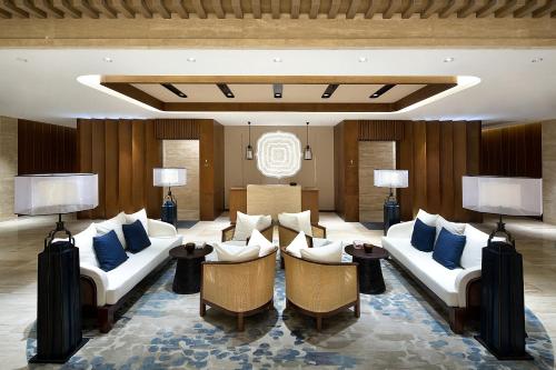 a living room with white couches and blue pillows at Wyndham Grand Plaza Royale Wenchang in Wenchang