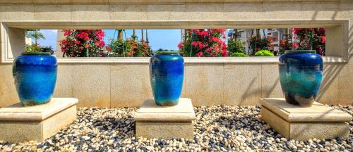three blue vases sitting on rocks in front of a window at Wyndham Grand Plaza Royale Wenchang in Wenchang
