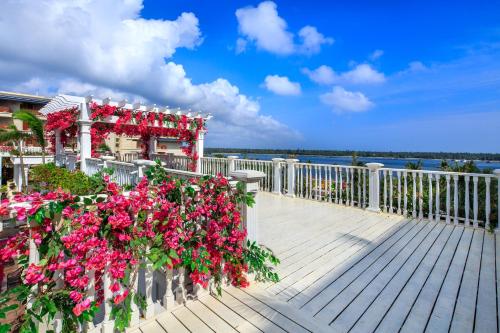 a balcony with pink flowers on a white fence at Wyndham Grand Plaza Royale Wenchang in Wenchang