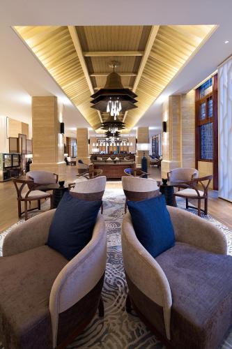 a lobby with couches and chairs in a room at Wyndham Grand Plaza Royale Wenchang in Wenchang