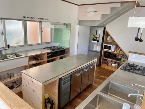 a kitchen with a sink and a counter top at 交流型ゲストハウス伊良部ジャーニーインIrabu Joureny INN#毎日みんなで夕食会#ゲストさんは20-30代が中心#海徒歩1分#空港車で5分#本格フィンランドサウナ付き#海と星と夕日が見える屋上あり in Miyako-jima
