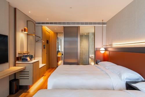 a hotel room with two beds and a television at 采寓halo house in Taichung