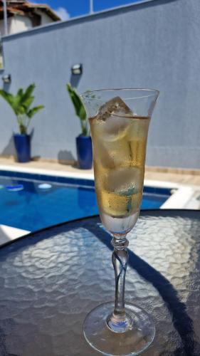 a drink in a glass sitting on a table at Suíte tripla com vista piscina em casa familiar de luxo em Itaipu in Niterói