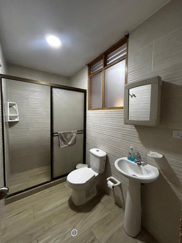 a bathroom with a toilet and a sink at Hostal Tayrona in Santa Marta