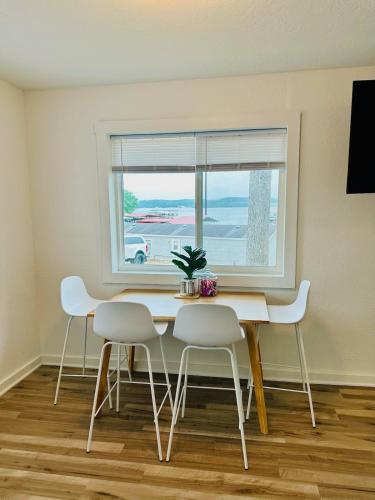 a dining room table with white chairs and a window at The whole family in Sunrise Beach