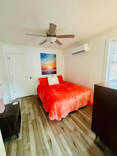 a bedroom with a red bed and a ceiling fan at The whole family in Sunrise Beach