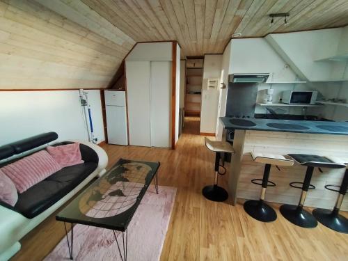 a living room with a couch and a table in a tiny house at L'éléphant Blanc de ConcarnOLoc in Concarneau