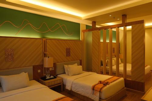 a hotel room with two beds and a mirror at Khas Parapat in Parapat