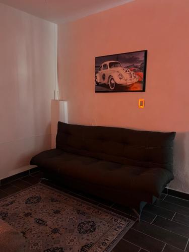 a living room with a couch and a picture of a car at Departamento Zona Hospital in Zamora de Hidalgo