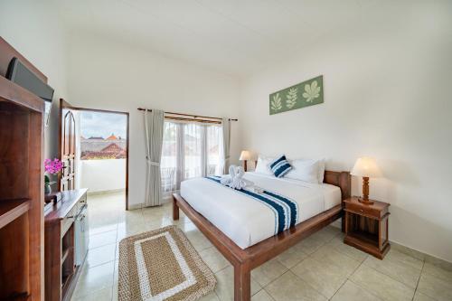 a bedroom with a large bed and a television at Nusa Indah Bungalow in Nusa Lembongan