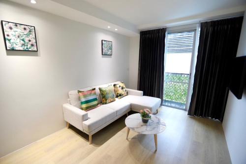 a living room with a white couch and a table at jasminespace in Khlong San