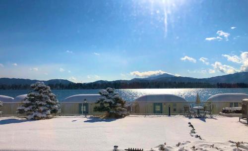a building with snow on the ground next to a lake at The Gran Resort Amanohashidate in Miyazu