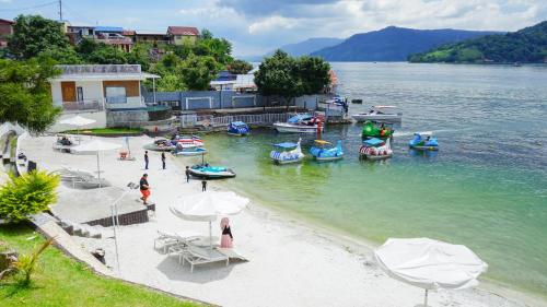a group of boats in the water on a beach at Khas Parapat in Parapat