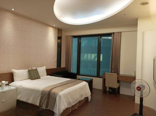 a hotel room with a bed and a large window at 85 Cape Inn in Kaohsiung