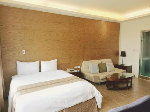 a hotel room with a bed and a chair at 85 Cape Inn in Kaohsiung