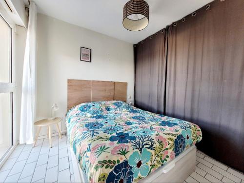 une chambre avec un lit avec un couvre-lit fleuri dans l'établissement Appartement moderne T2, balcon, 4 pers, proche plage - FR-1-794-159, à Canet