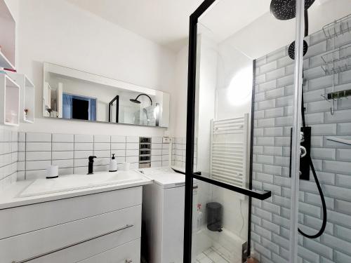 une salle de bain blanche avec une douche et un lavabo dans l'établissement Appartement moderne T2, balcon, 4 pers, proche plage - FR-1-794-159, à Canet