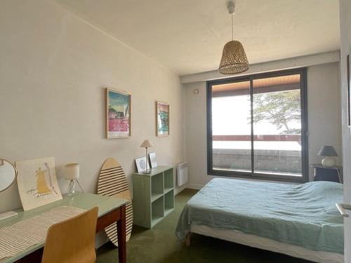 une chambre avec un lit, un bureau et une fenêtre dans l'établissement Grande maison familiale au Roaliguen, vue mer - FR-1-639-133, à Sarzeau