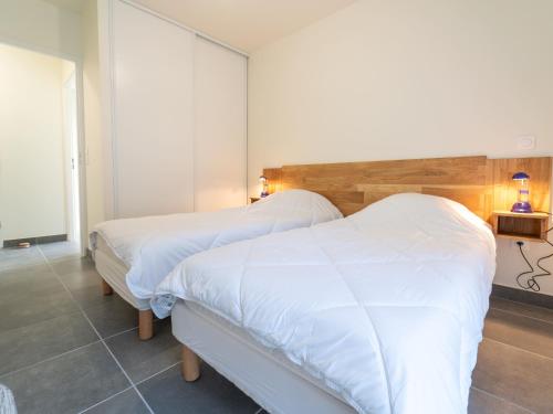 deux lits dans une chambre d'hôtel avec des draps blancs dans l'établissement Appartement Neuf à Mimizan : Confort & Proximité de la Plage avec Parking - FR-1-50-155, à Mimizan