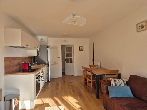 une cuisine et un salon avec un canapé et une table dans l'établissement Appartement 4 Personnes - Vue Mer proche Plage - FR-1-482-149, à Fort-Mahon-Plage