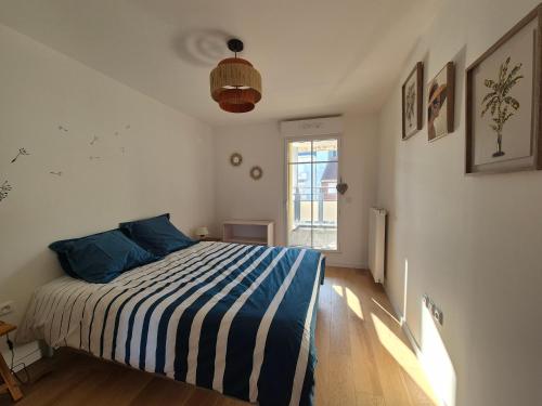 une chambre avec un lit avec des oreillers bleus et une fenêtre dans l'établissement Appartement 4 Personnes - Vue Mer proche Plage - FR-1-482-149, à Fort-Mahon-Plage