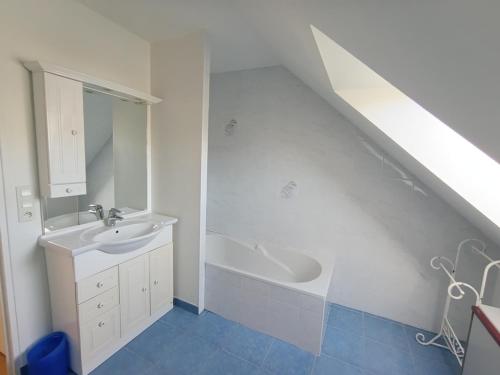 une salle de bain avec un lavabo et une baignoire dans l'établissement Maison Familiale Vue Mer à Saint-Gildas-de-Rhuys - FR-1-639-132, à Saint-Gildas-de-Rhuys