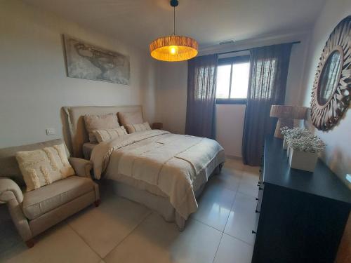 une chambre avec un lit et une chaise dedans dans l'établissement Appartement Confortable avec Vue, WIFI et Climatisation - FR-1-776-122, à Saint-Cyprien