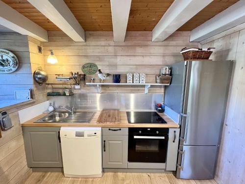 une cuisine avec un réfrigérateur en acier inoxydable et un évier dans l'établissement Charmante maison à Plouhinec, calme et terrasse ensoleillée, animaux acceptés - FR-1-479-213, à Plouhinec