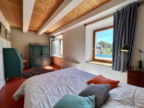 une chambre avec un grand lit et une fenêtre dans l'établissement Charmante maison à Plouhinec, calme et terrasse ensoleillée, animaux acceptés - FR-1-479-213, à Plouhinec